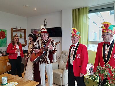 Das Faschingsprinzenpaar und sein Hofstaat singen im Wintergarten des Hospizes das Prinzenlied.